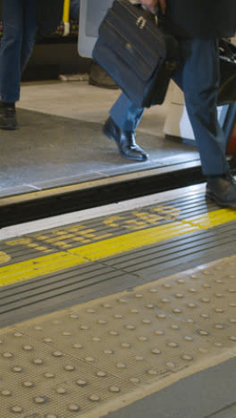 Vertical-Video-Of-Mind-The-Gap-Warning-On-Edge-Of-Underground-Station-Platform-With-Tube-Train-Arriving